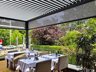Optional pergola side screens protect against mosquitos and insects for enhanced outdoor dining